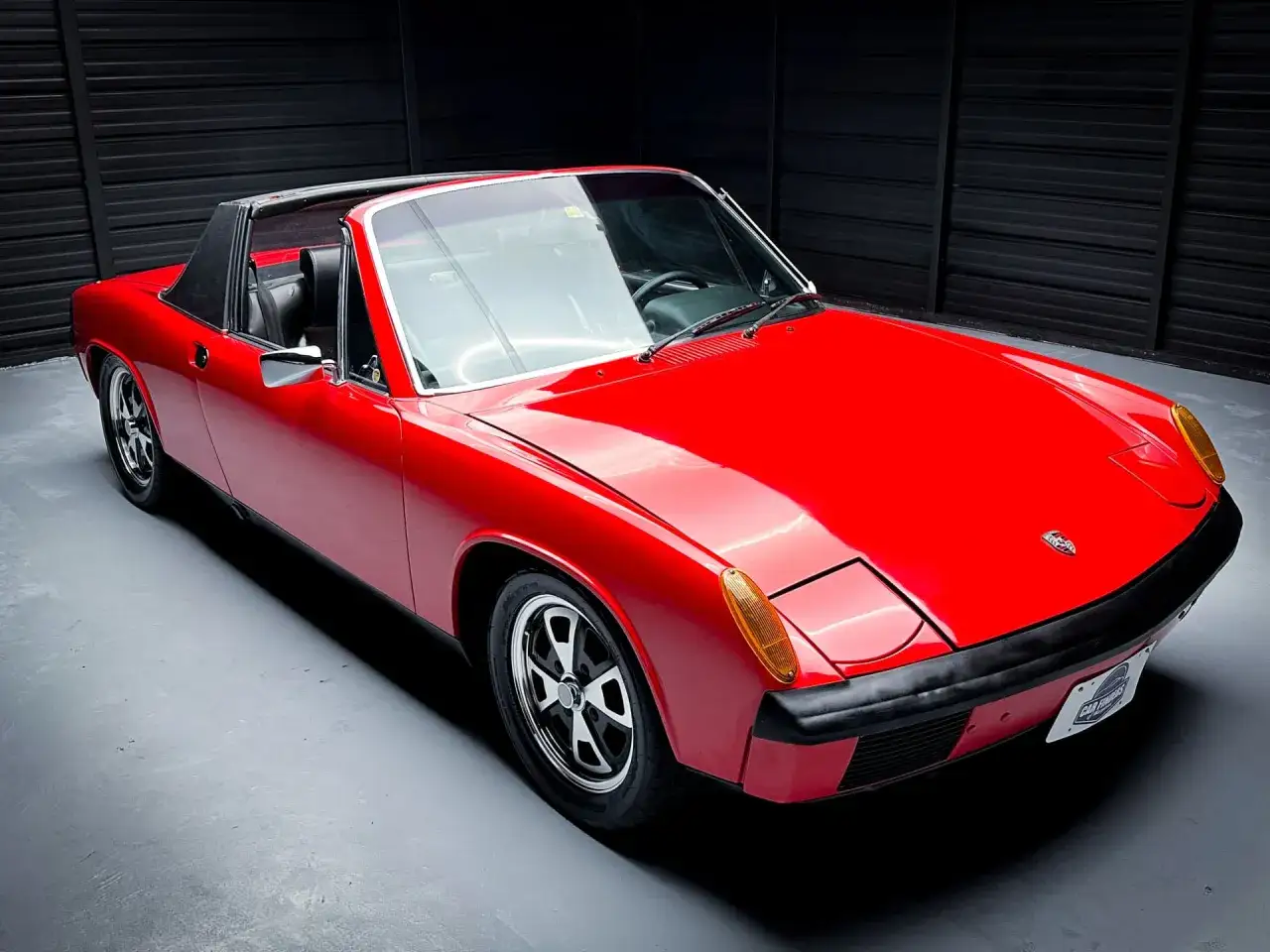 Czerwony Porsche 914 z czarnym dachem targa, gotowy do jazdy po krętych drogach.