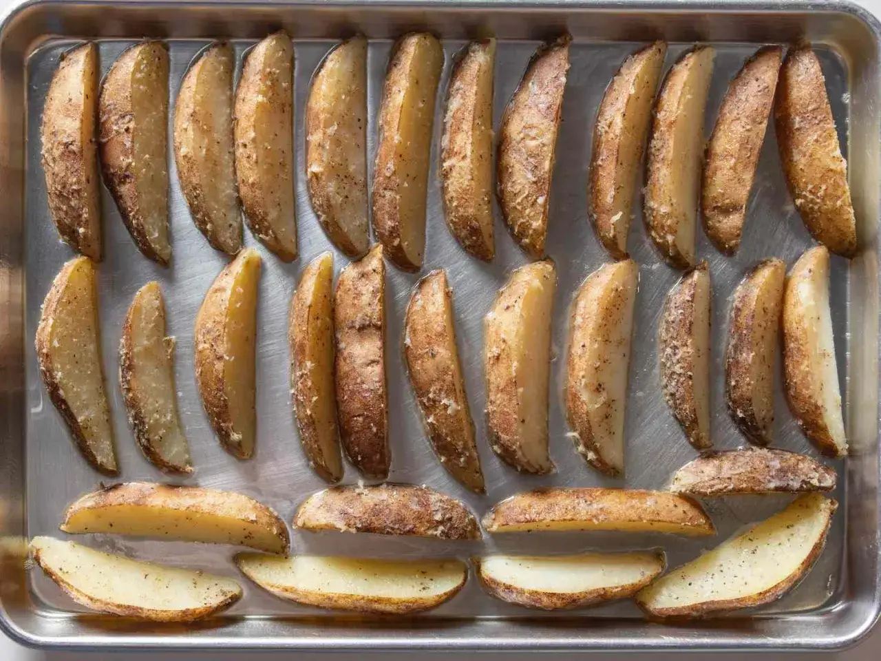 Klyftpotatis i ugn, gyllene och kryddade, redo att avnjutas.
