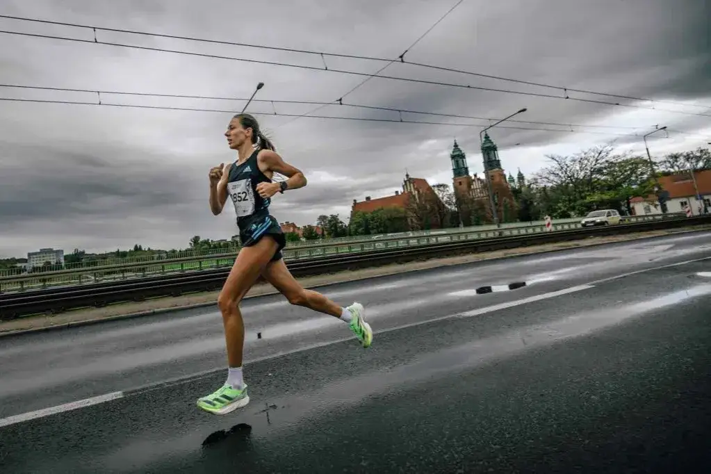 Biegacz w deszczu z zegarkiem sportowym