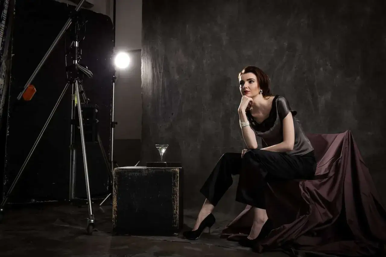 Modella elegante in posa, con luci e attrezzatura da studio. Chiss&agrave; quanto guadagna un fotografo per scatti cos&igrave; raffinati.