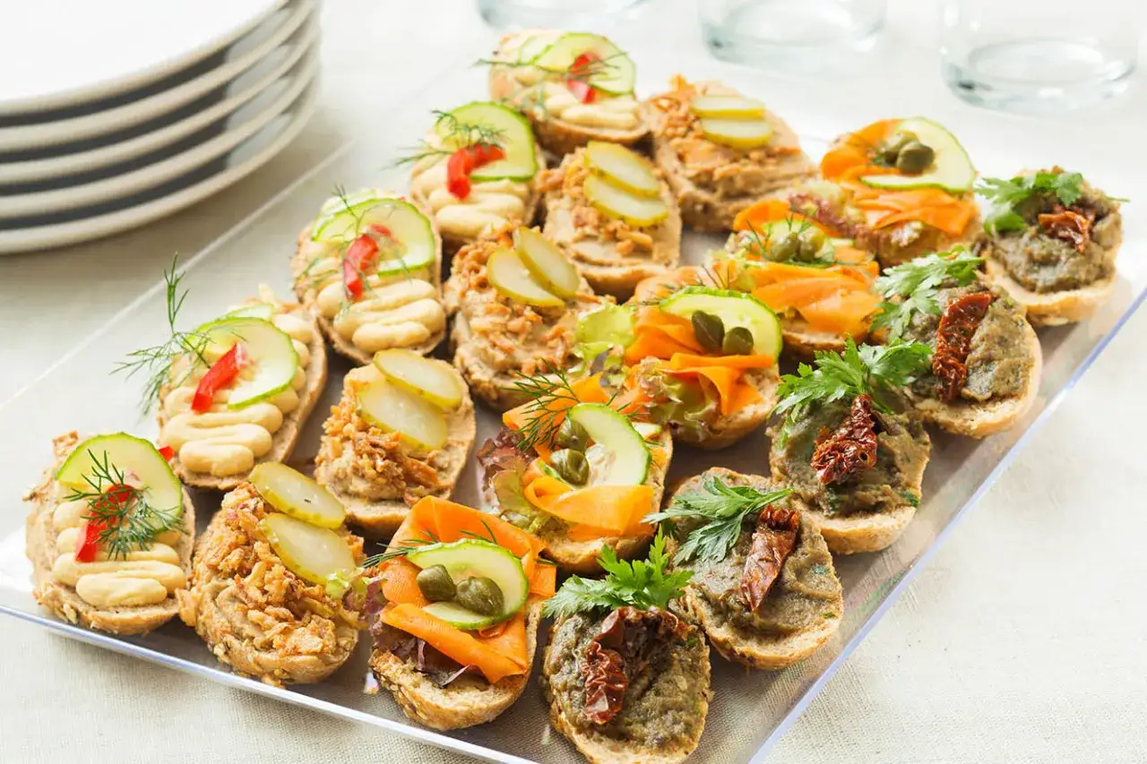 Pan kanapka catering: kolorowe bruschetty z warzywami, łososiem i pastami. Idealne na przyjęcie.