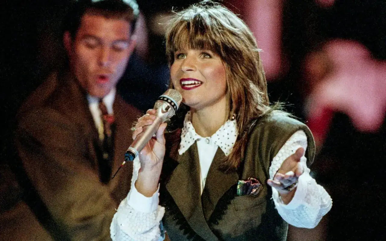 Carola, en ikonisk svensk eurovision vinnare, sjunger med mikrofonen i handen.