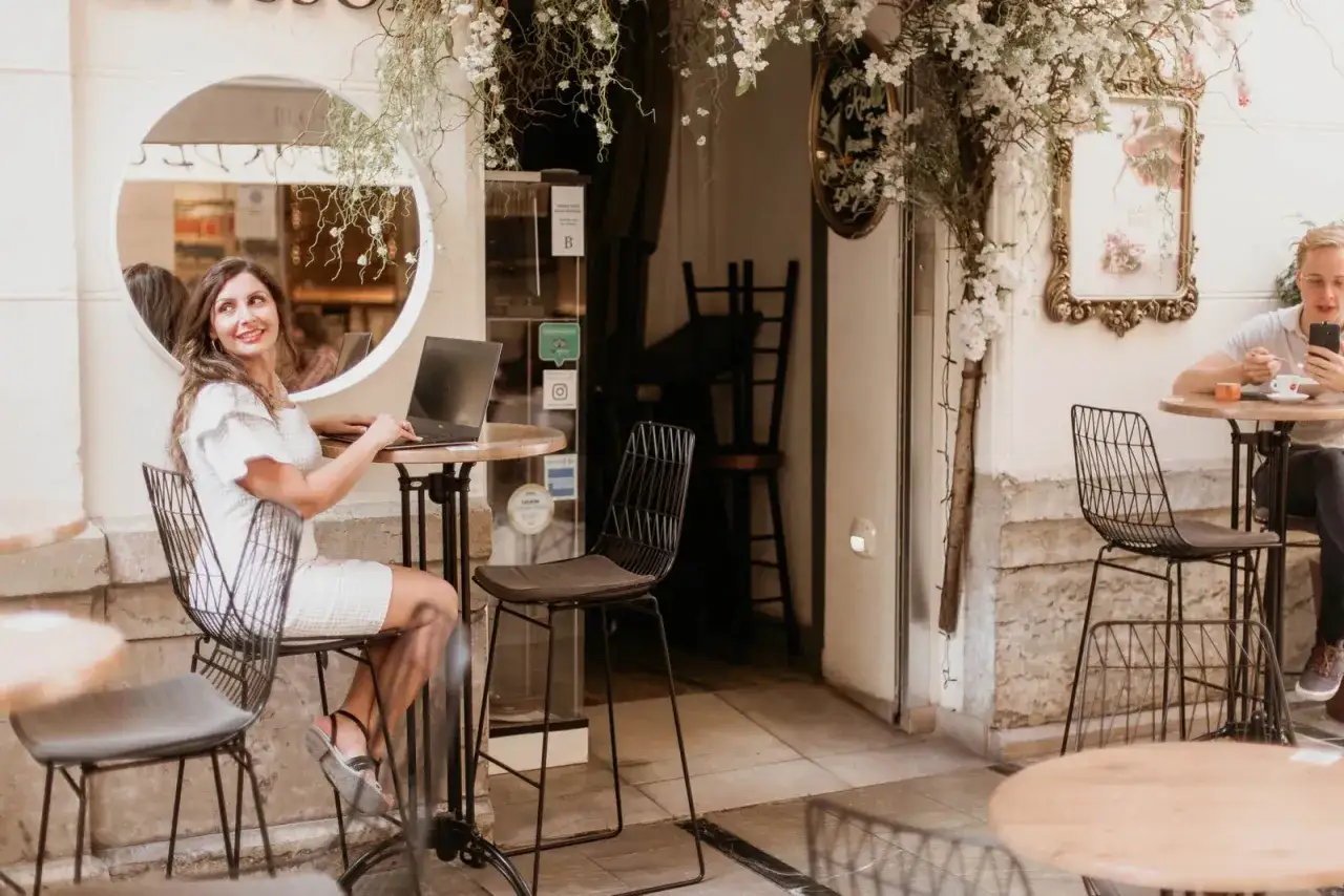 Mujer trabajando en port&aacute;til en terraza, reflejando la diferencia entre decorador y dise&ntilde;ador de interiores.
