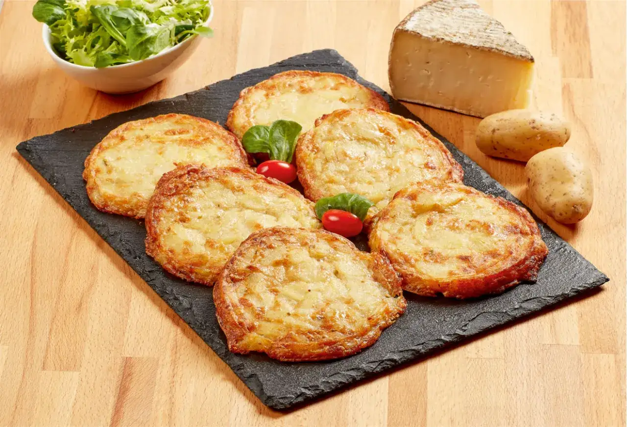Six d&eacute;licieuses truffades de l'Aubrac dor&eacute;es, accompagn&eacute;es de leurs ingr&eacute;dients bruts : pommes de terre, fromage et salade verte.