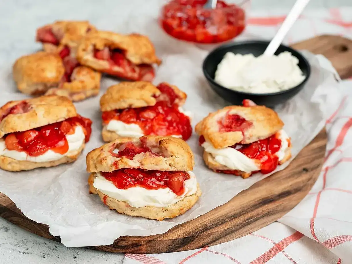 Färska scones fyllda med vispad grädde och en härlig jordgubbssylt. Perfekt för en fika, kanske med ett enkelt jordgubbssylt recept.