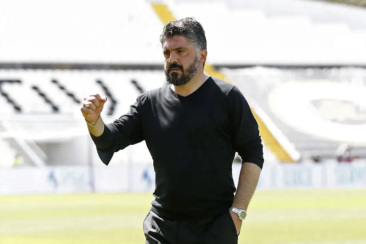 Gennaro Gattuso, zaciśnięta pięść w geście motywacji, na tle stadionu.