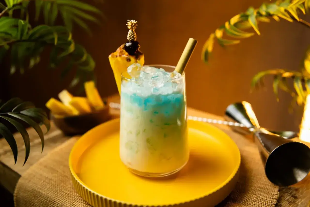 Erfrischender Swimmingpool Cocktail mit Ananas-Garnitur und Eis, bereit für den Sommer.