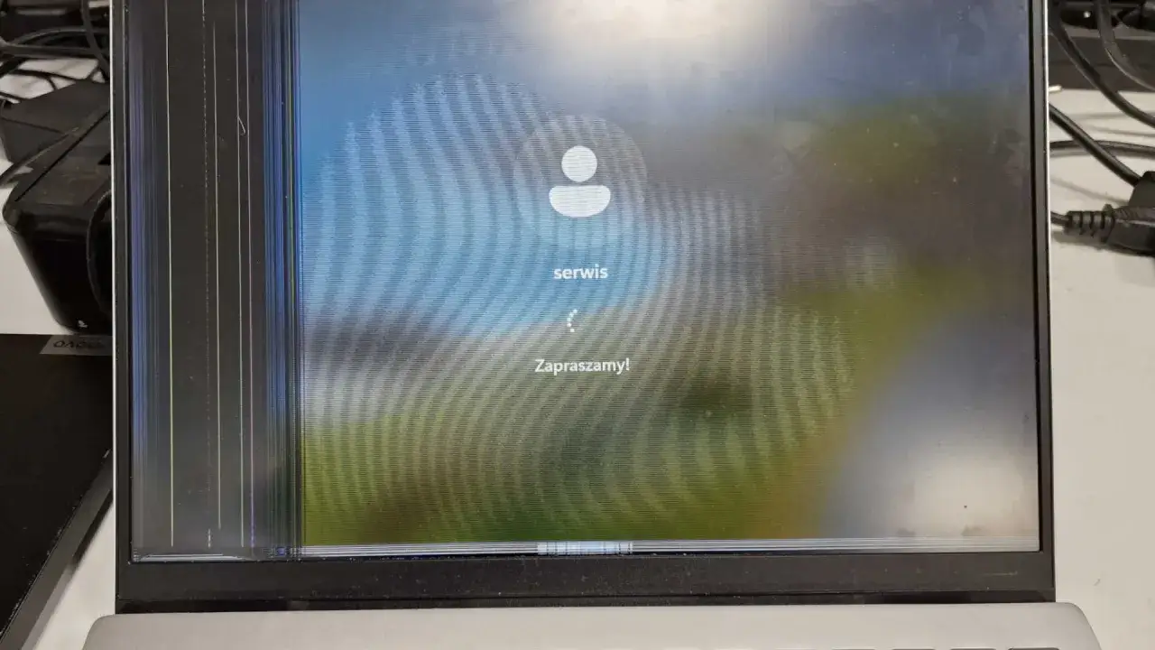 Uszkodzony ekran laptopa, widoczne pęknięcia i zakłócenia obrazu. Czas na wymianę matrycy w laptopie.