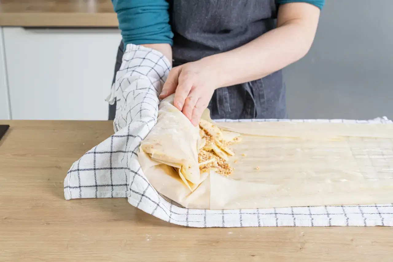 H&auml;nde falten Strudelteig mit Nussf&uuml;llung. So kann man Strudelteig einfrieren, um ihn sp&auml;ter zu backen.
