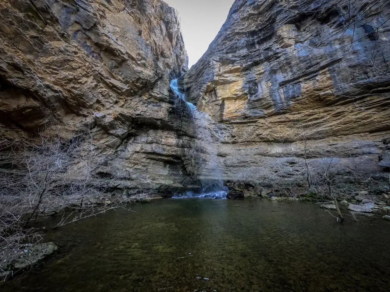 Impresionantes cascadas en Guadalajara, cayendo entre imponentes paredes rocosas hacia una poza de aguas cristalinas.