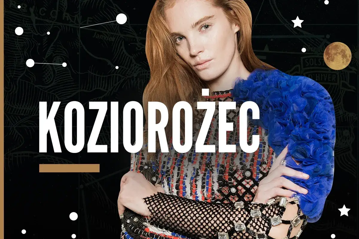 Kobieta Koziorożec w stylizacji inspirowanej gwiazdami. Jej spojrzenie jest intensywne, a strój ozdobiony niebieskimi kwiatami i błyszczącymi kryształami.