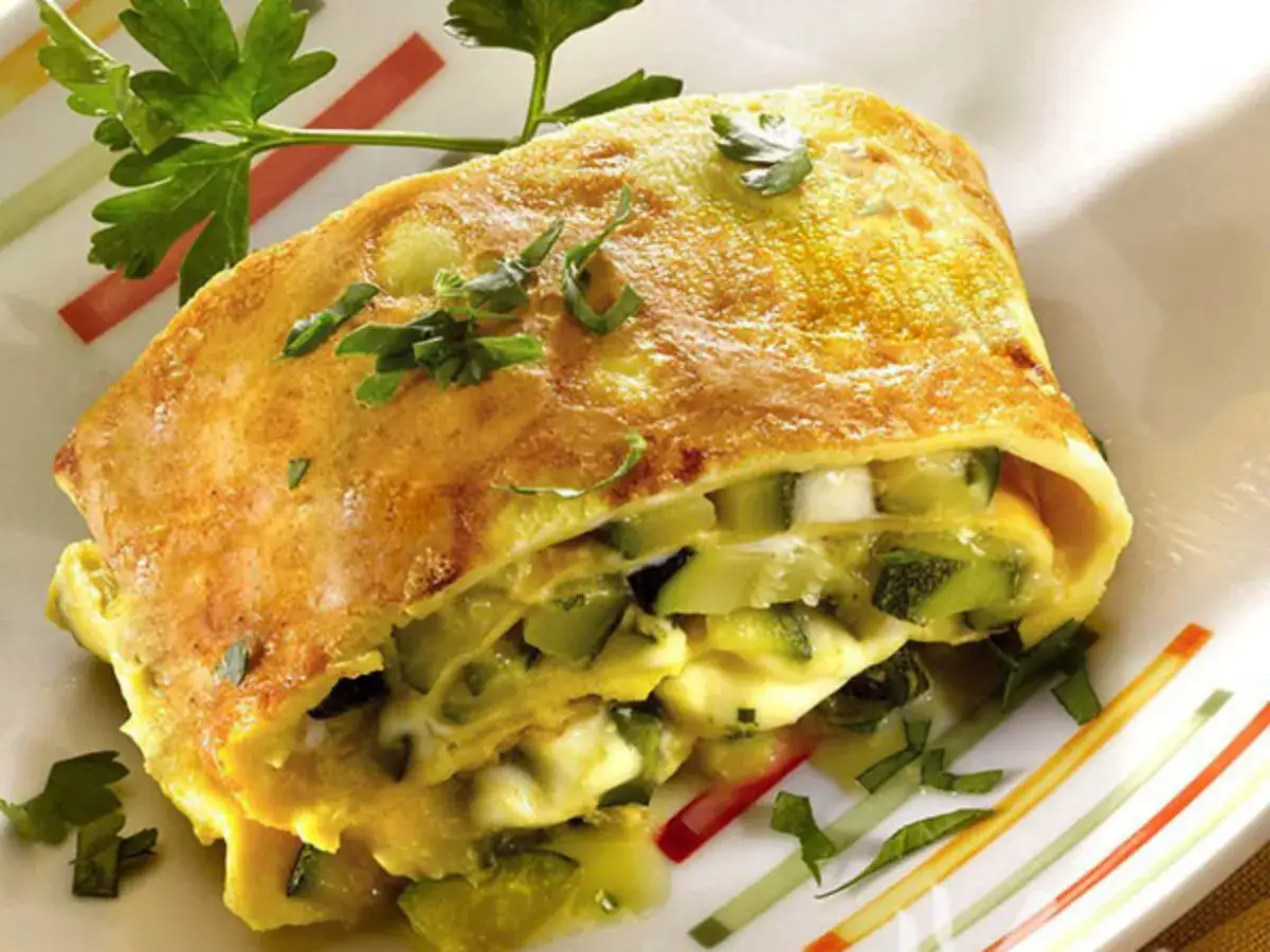 Crepes senza burro ripiene di zucchine e formaggio, guarnite con prezzemolo fresco. Un piatto leggero e gustoso.