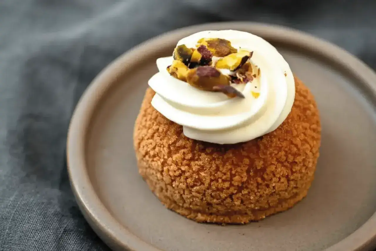 Un chou garni de crème et de pistaches, une des spécialités culinaires parisiennes à savourer.