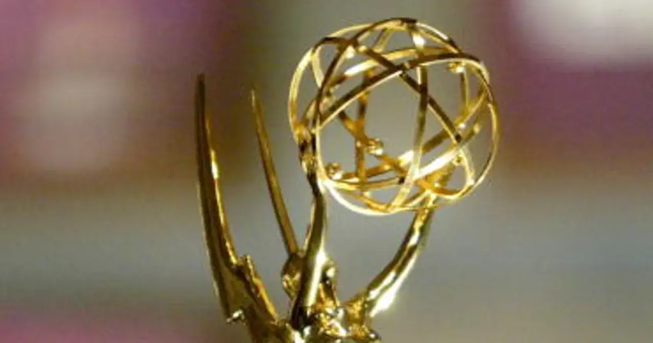 Złota statuetka nagrody Emmy, symbol najwyższych osiągnięć w branży telewizyjnej, lśni na tle rozmytego tła.