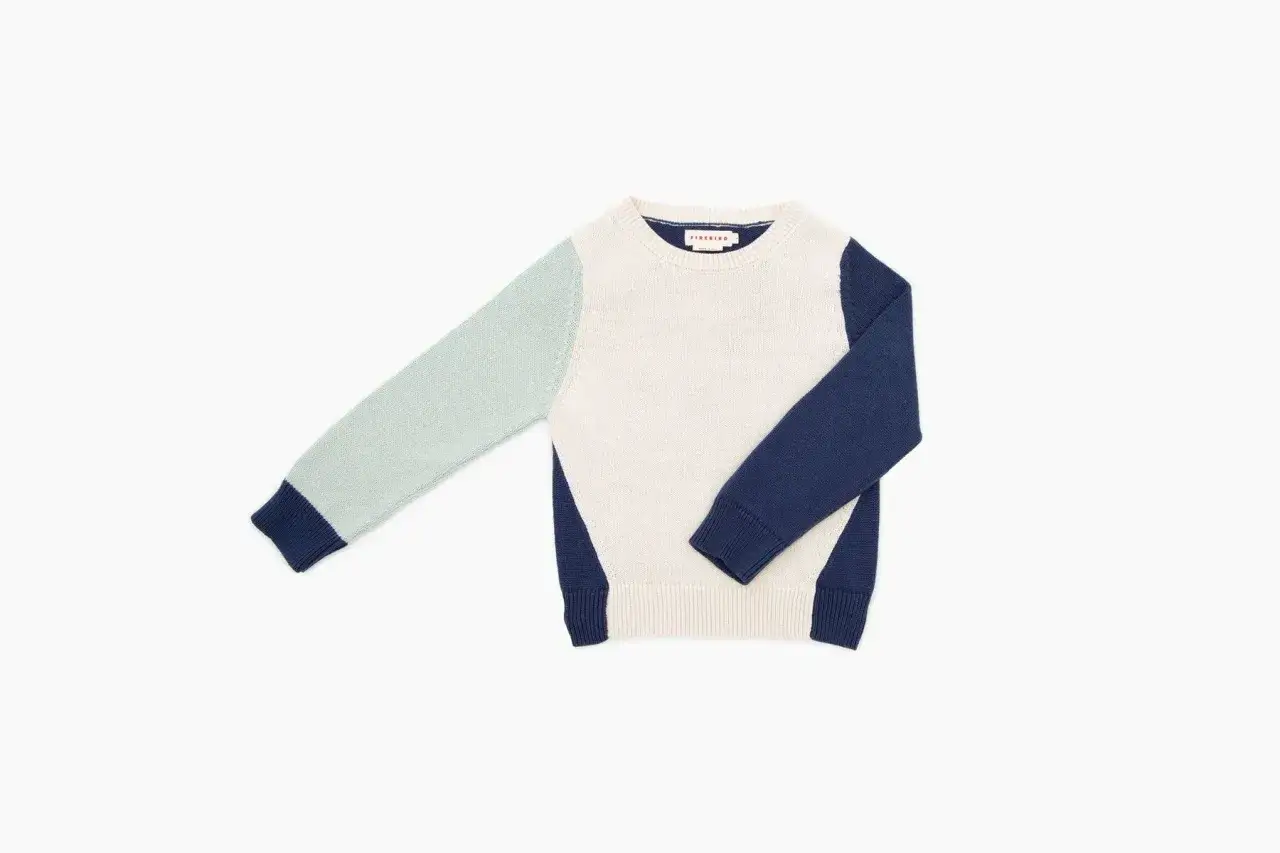 Sweter w kolorach ecru, miętowym i granatowym. Idealny przykład, jak robić zdjęcia ubrań do sprzedaży, by podkreślić ich unikalny design.