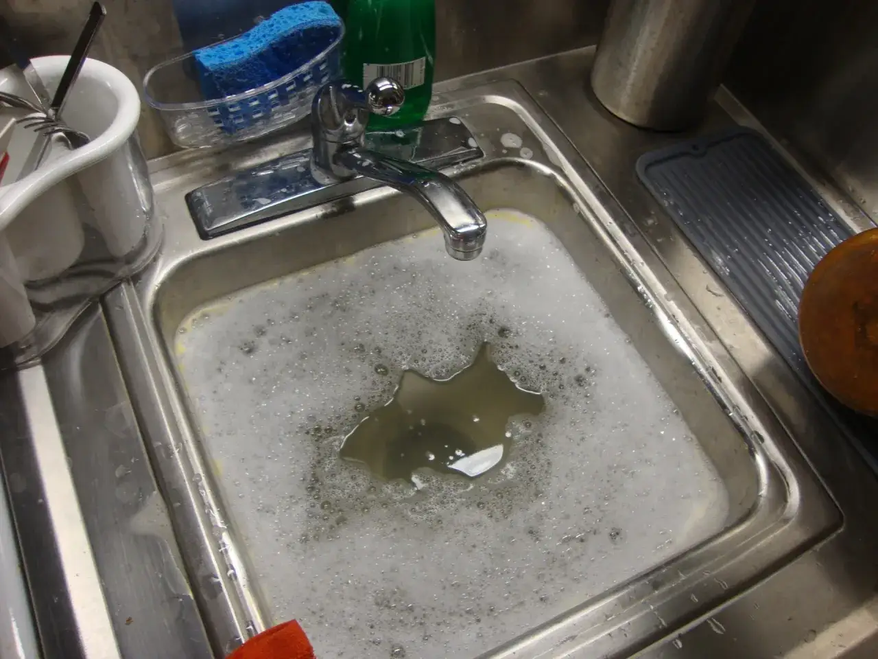 &Eacute;vier bouch&eacute;, tentative de d&eacute;boucher &eacute;vier eau bouillante. La vaisselle attend, le robinet est ouvert.