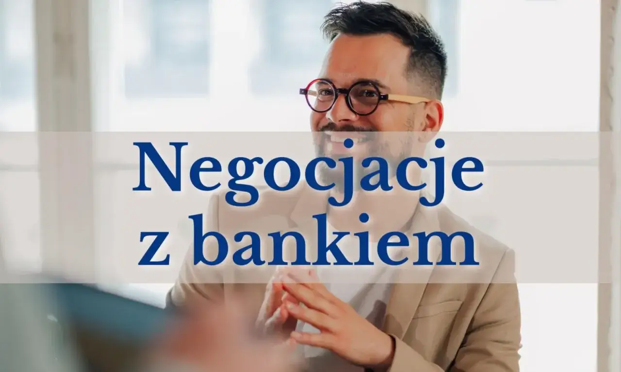 Uśmiechnięty mężczyzna w okularach prowadzi negocjacje z bankiem. Rozmowa o renegocjacji kredytu hipotecznego.