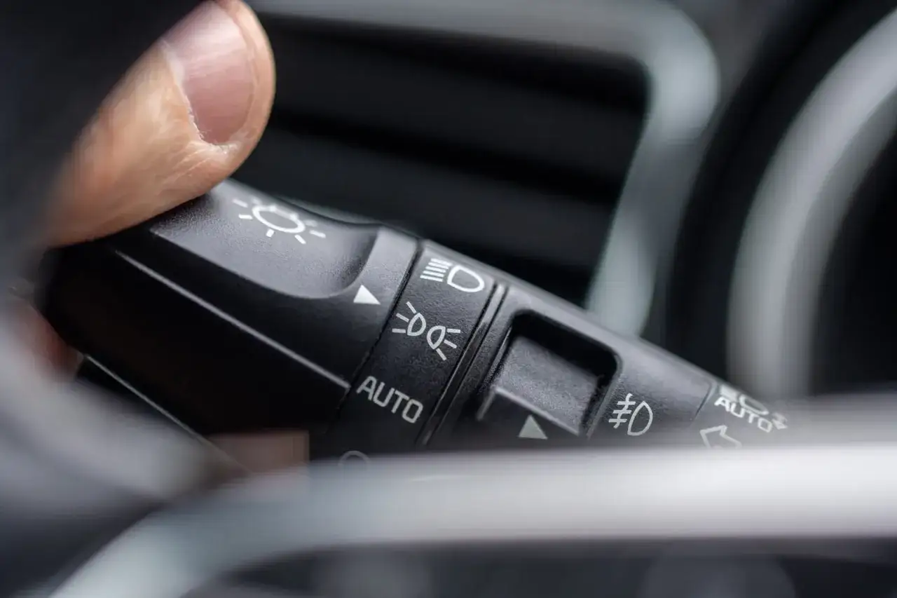 Palec naciska dźwignię kierunkowskazów, ustawiając światła pozycyjne w trybie AUTO.