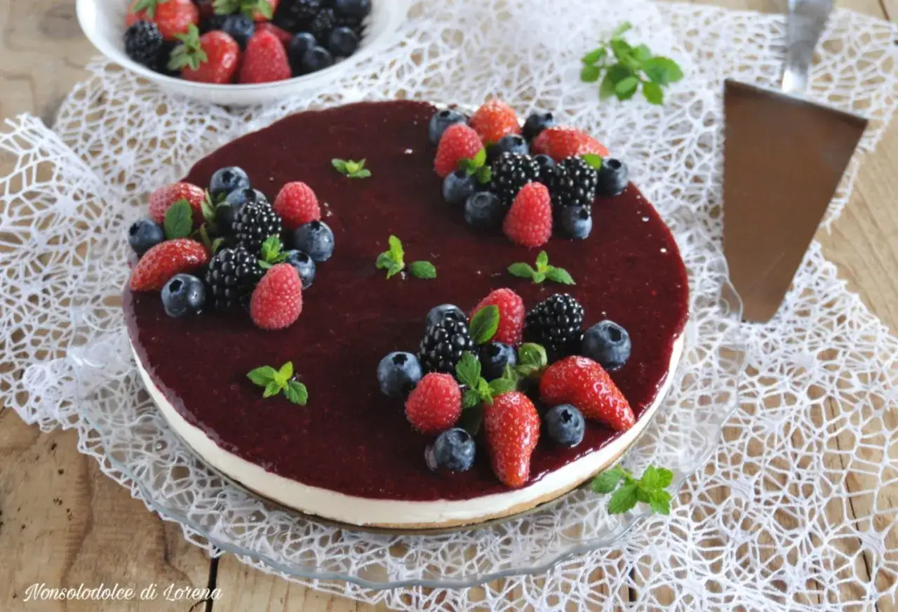 Torta fredda allo yogurt con frutti di bosco freschi e una glassa lucida. Perfetta per un dessert estivo.