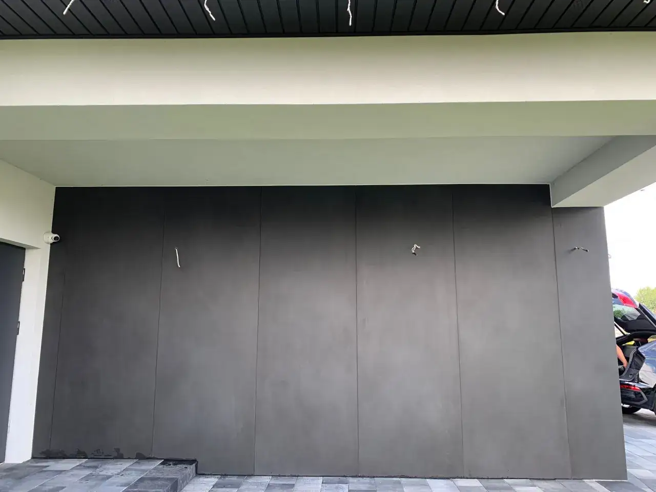 Nowoczesna elewacja z płyt spiek kwarcowy w ciemnym kolorze, tworząca minimalistyczną i elegancką bryłę budynku.