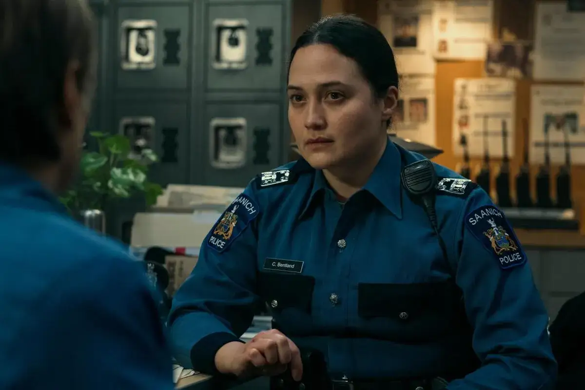 En polis i uniformen serie, med Saanich Police-märke på ärmen, ser allvarligt på någon utanför bild.