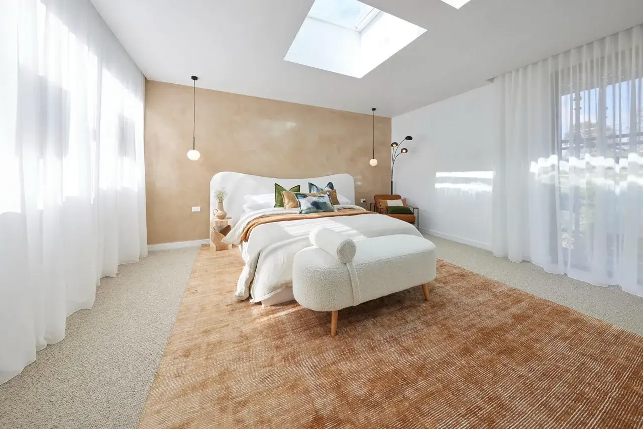 Camera da letto con pareti particolari dietro la testata in cartongesso, illuminata da un lucernario.