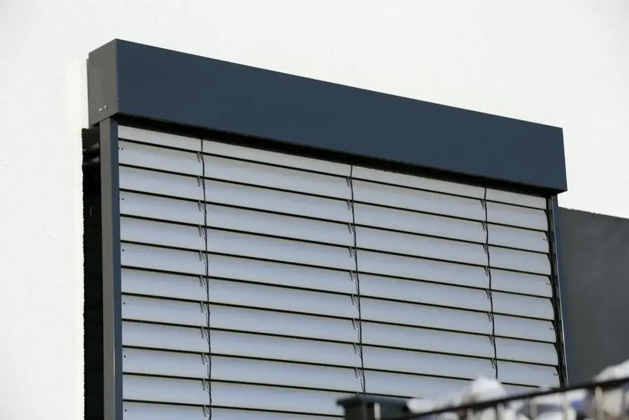 Nowoczesne rolety zewnętrzne z aluminium, chroniące przed słońcem i zapewniające prywatność.