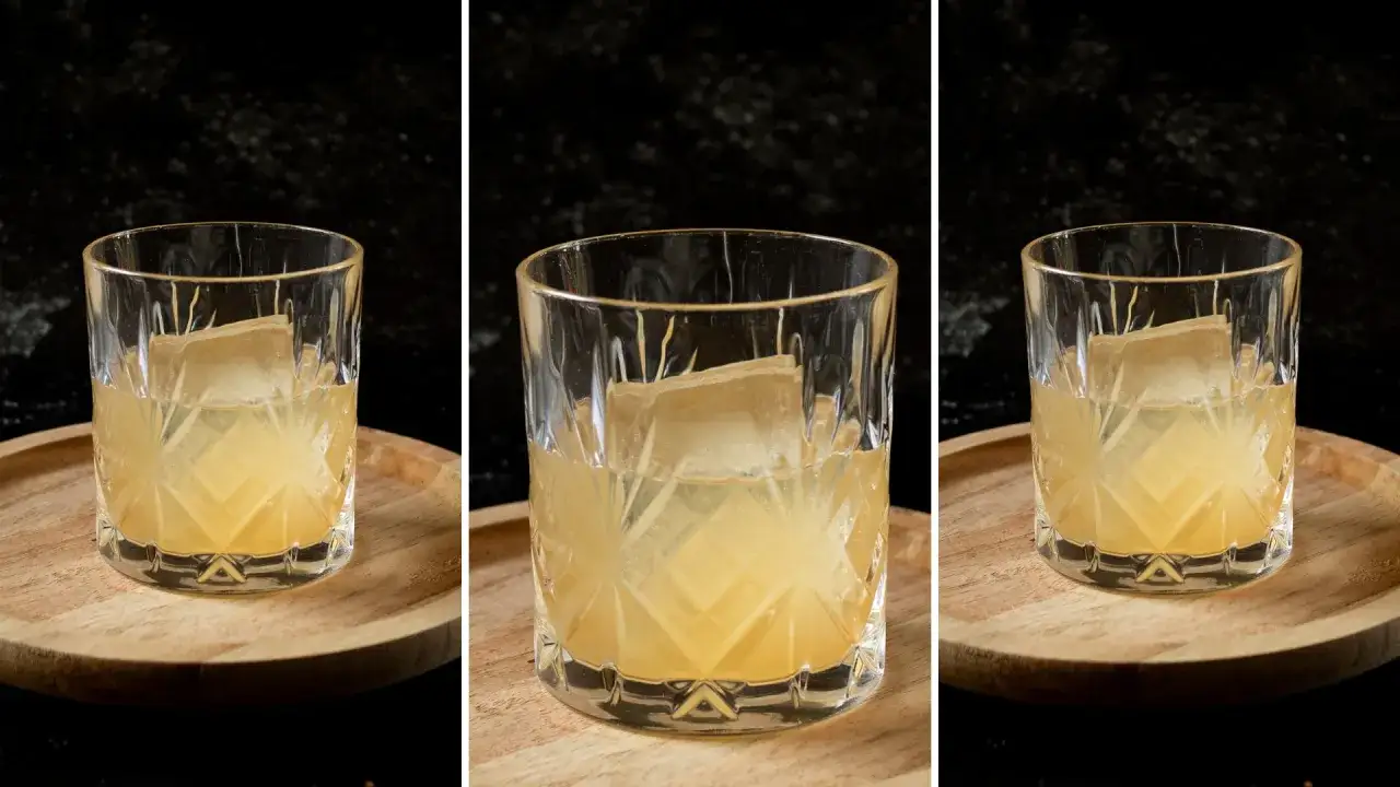 Trzy szklanki z drinkiem, w którym dominuje whisky z miodem, z dużym kawałkiem lodu, na drewnianych podstawkach.