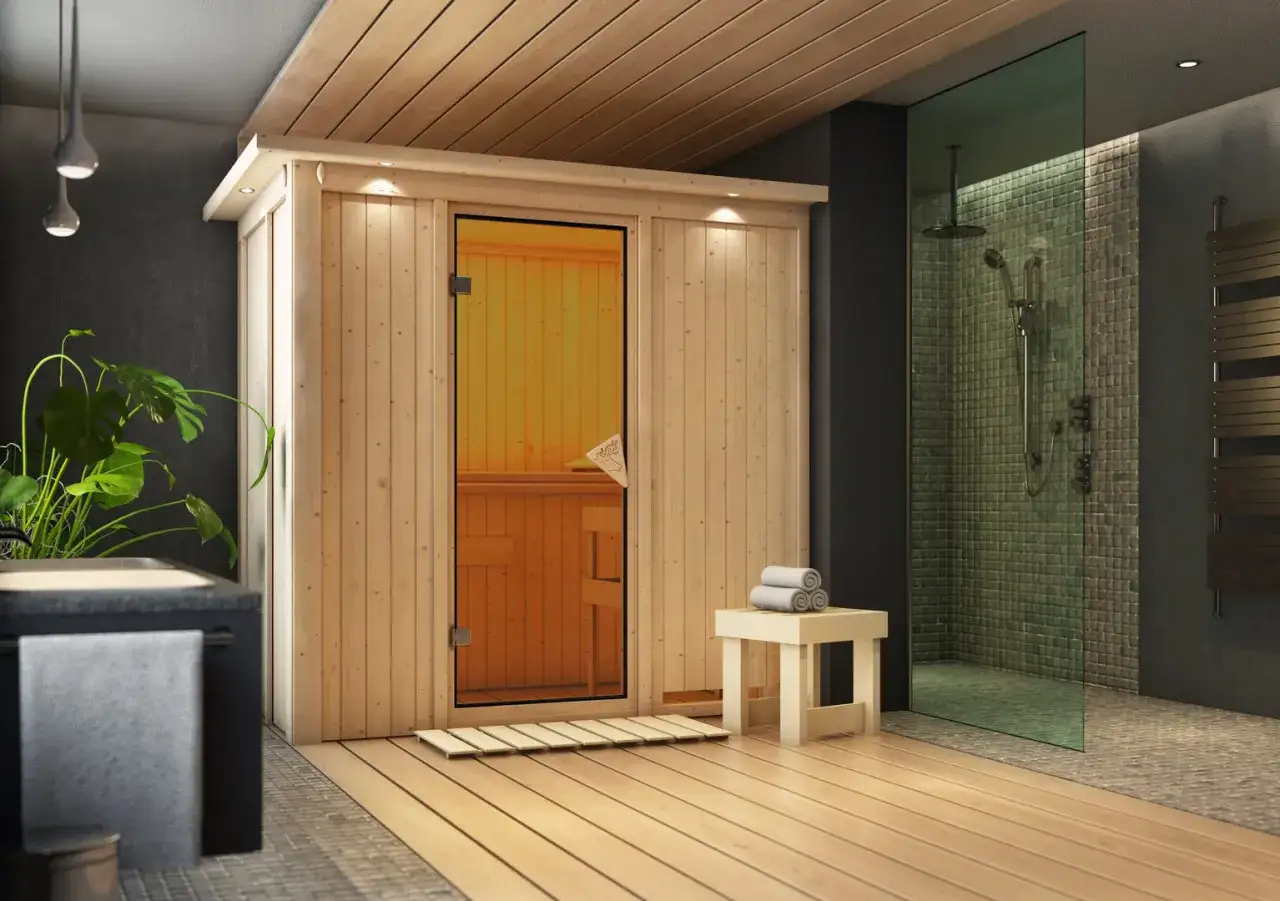 Interno moderno con sauna a infrarossi in legno, doccia a pioggia e piante.