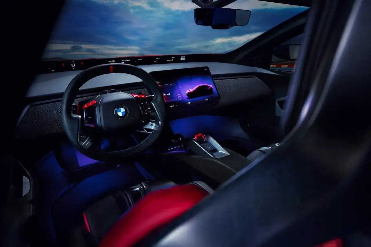 Wnętrze BMW M3 2025 z nowoczesnym kokpitem, ekranem multimedialnym i sportowymi fotelami.