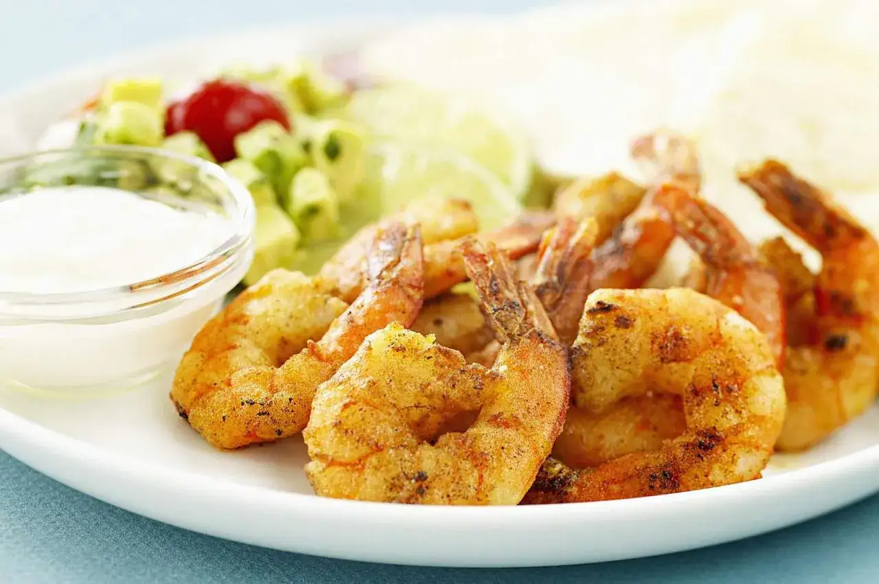 Gebratene Garnelen als Vorspeise, serviert mit einem Dip und frischem Salat.
