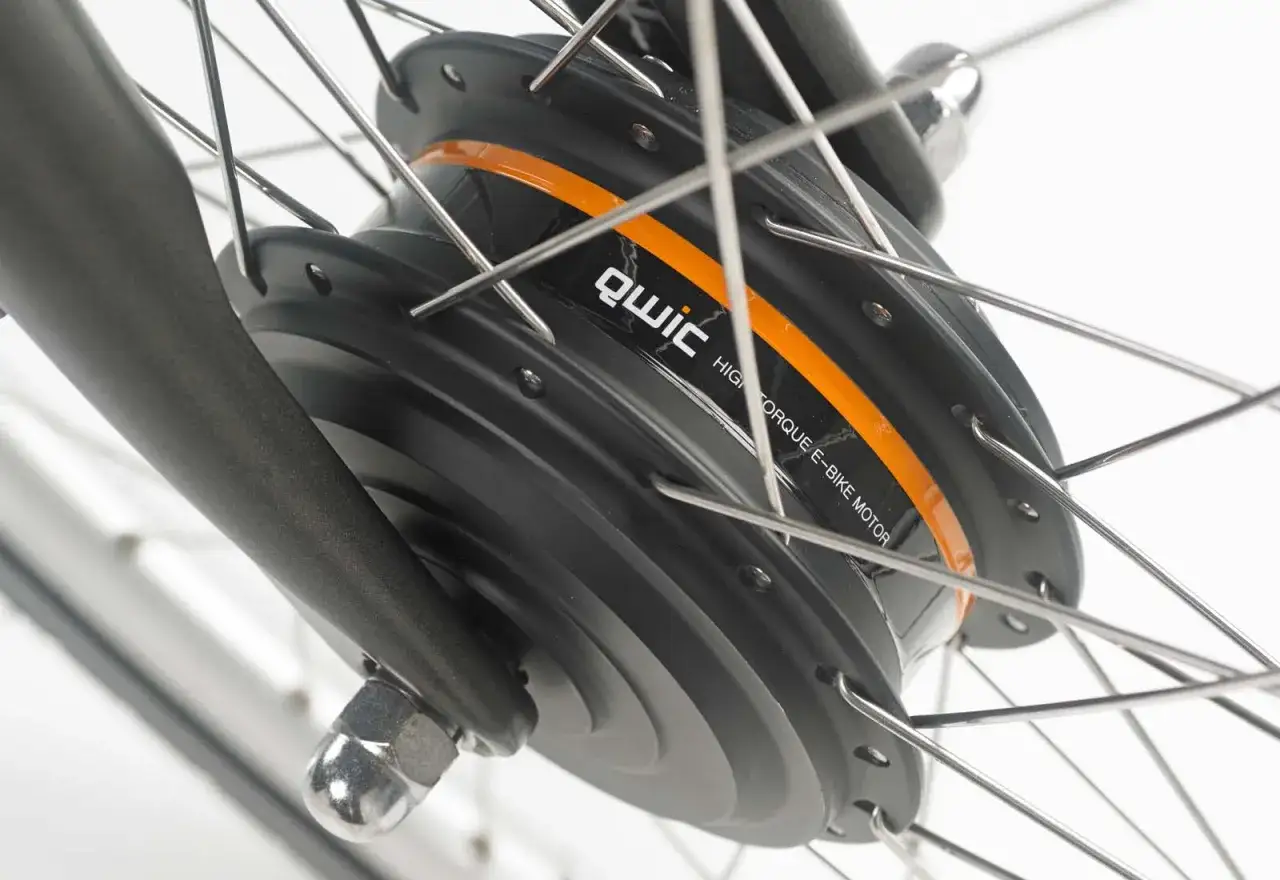 Close-up van een e-bike voorwielmotor met het merk Qwic. De motor is zwart met een oranje accent en de tekst