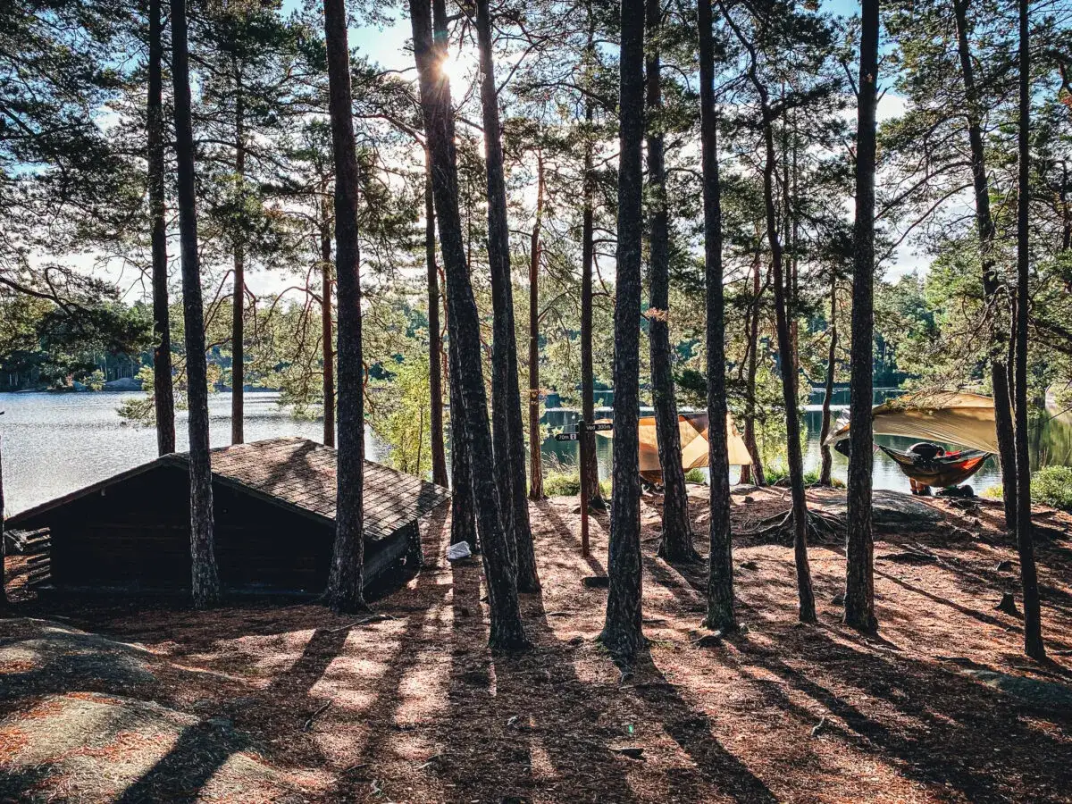 Enkel stuga och h&auml;ngmatta vid sj&ouml;n, perfekt f&ouml;r att sova i vindskydd.