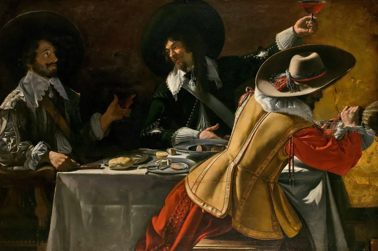 Drei Männer in barocken Kostümen, wie bei Dumas' Musketieren, trinken und speisen. Einer hebt ein Glas.