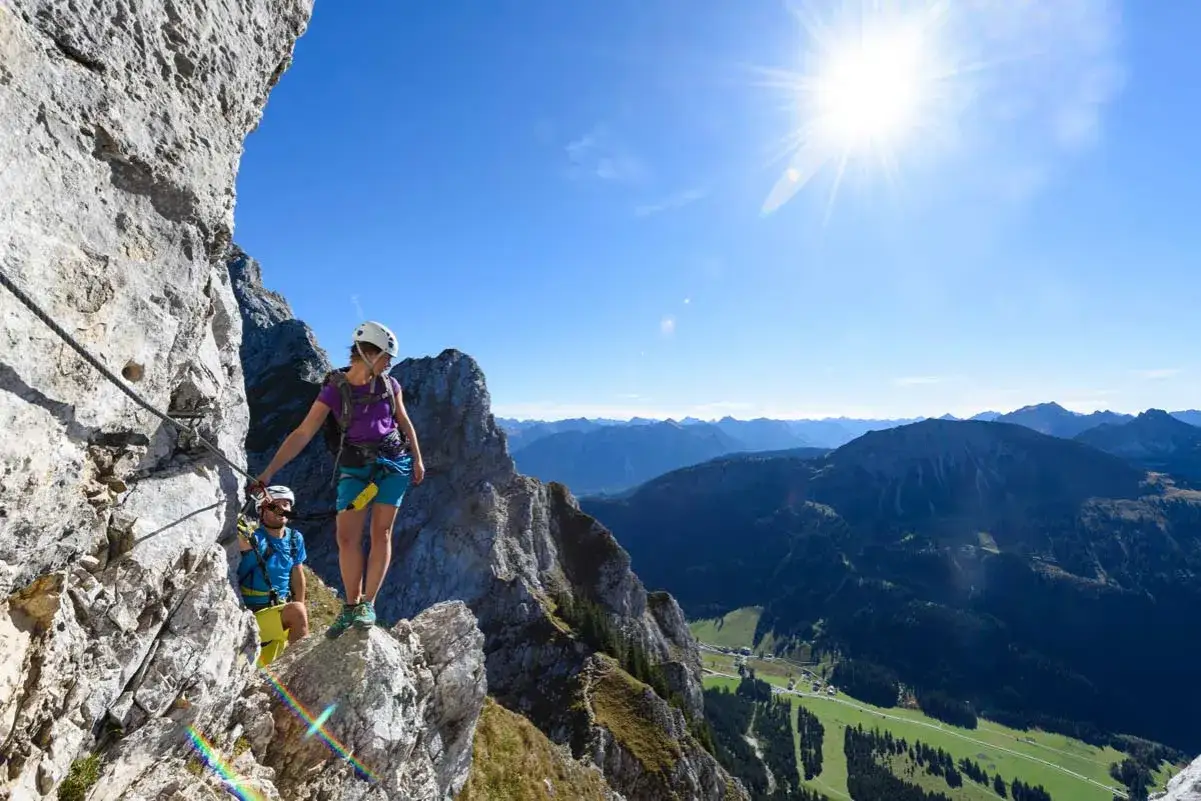 Zwei Personen genie&szlig;en die Aussicht auf einer Klettersteig-Tour in den deutschen Alpen.