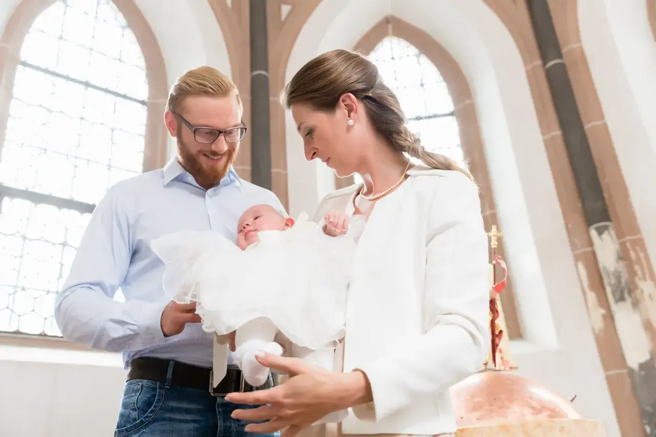 Rodzice z niemowlęciem w kościele. Czy po ślubie cywilnym można być chrzestnym? To pytanie nurtuje wiele par.