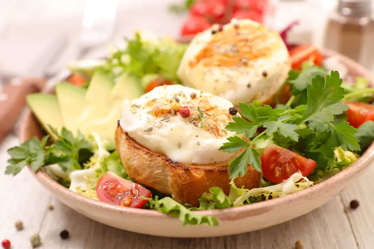 Salade gourmande avec crottin de Chavignol au four sur toast, avocat, tomates cerises et persil. Une recette simple et savoureuse.