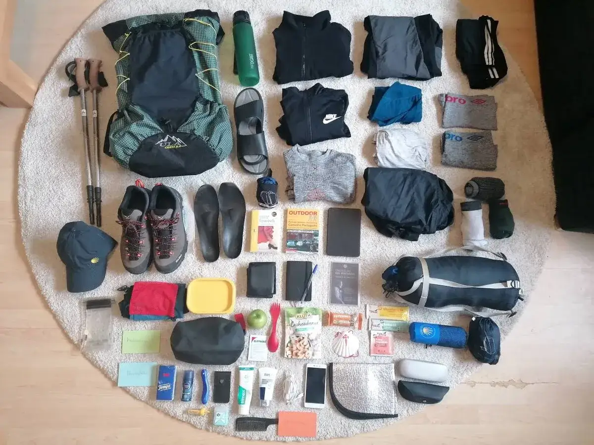 Packliste Jakobsweg: Rucksack, Wanderschuhe, Kleidung, Trekkingst&ouml;cke, Wasserflasche, Snacks, Hygieneartikel und ein Schlafsack f&uuml;r die Pilgerreise.