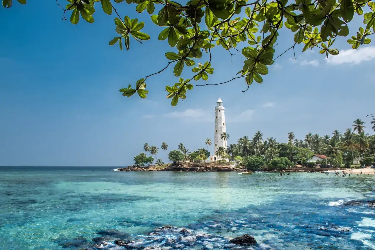 Piękna plaża z latarnią morską i palmami. Idealne miejsce, by zapytać, kiedy jechać na Sri Lankę.