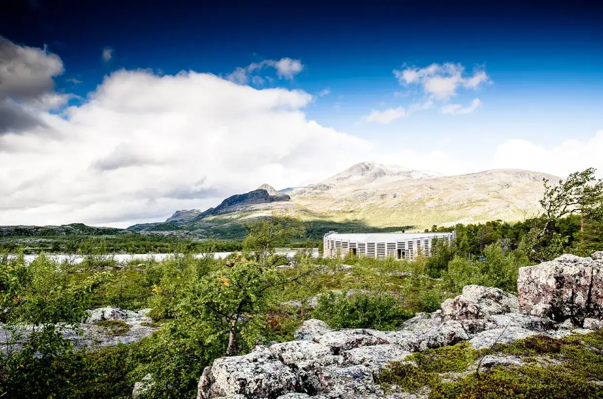 Vacker vy &ouml;ver G&auml;llivare, Sverige, med berg i bakgrunden och en modern byggnad i f&ouml;rgrunden.