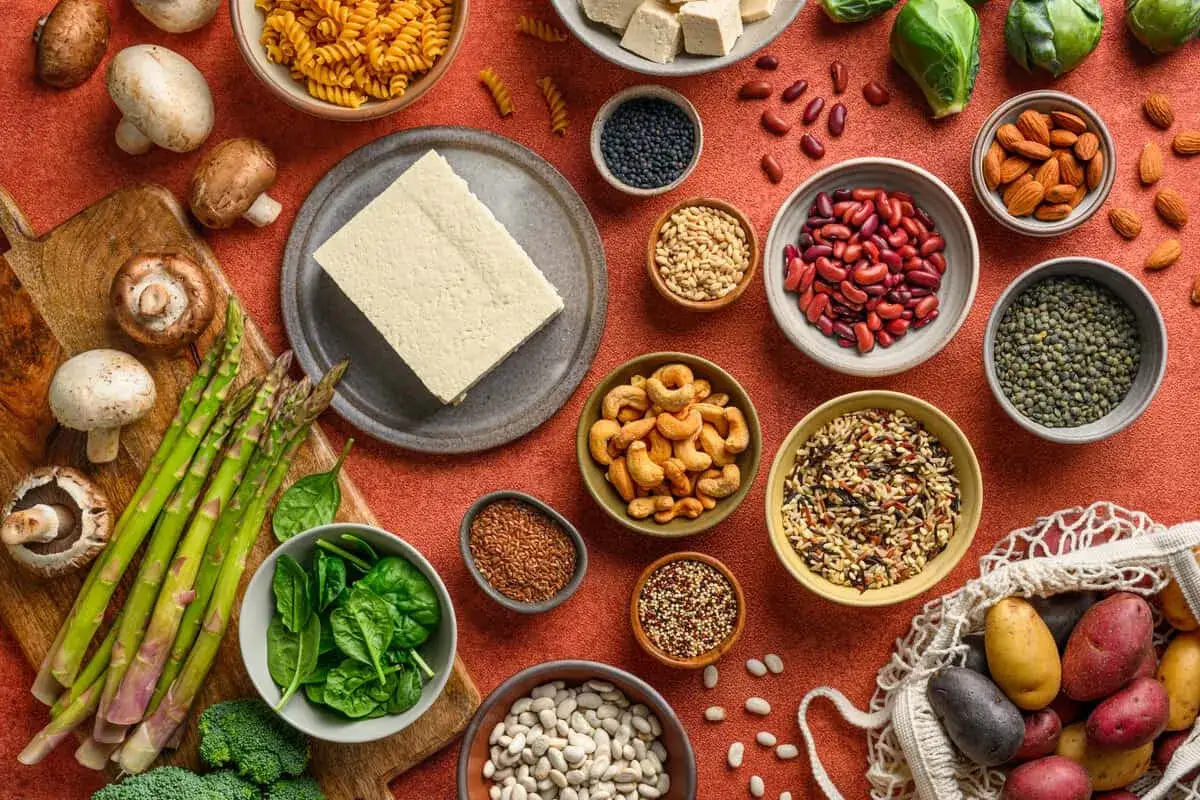 Vielfalt an vegetarischen Proteinquellen: Tofu, Linsen, Bohnen, Nüsse, Samen, Reis und Spargel.