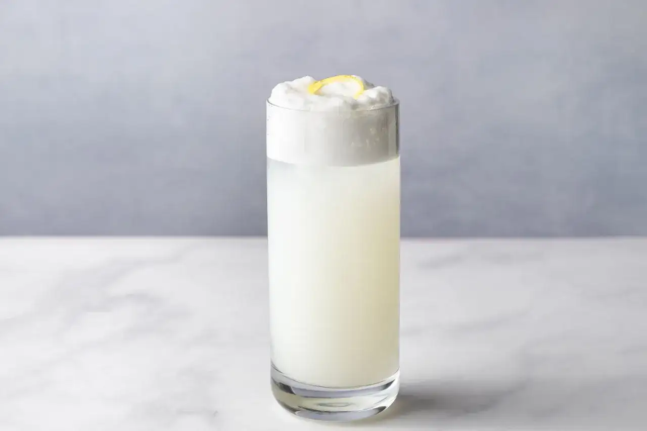 Ein erfrischender Gin Fizz mit cremigem Schaum und Zitronenzeste.