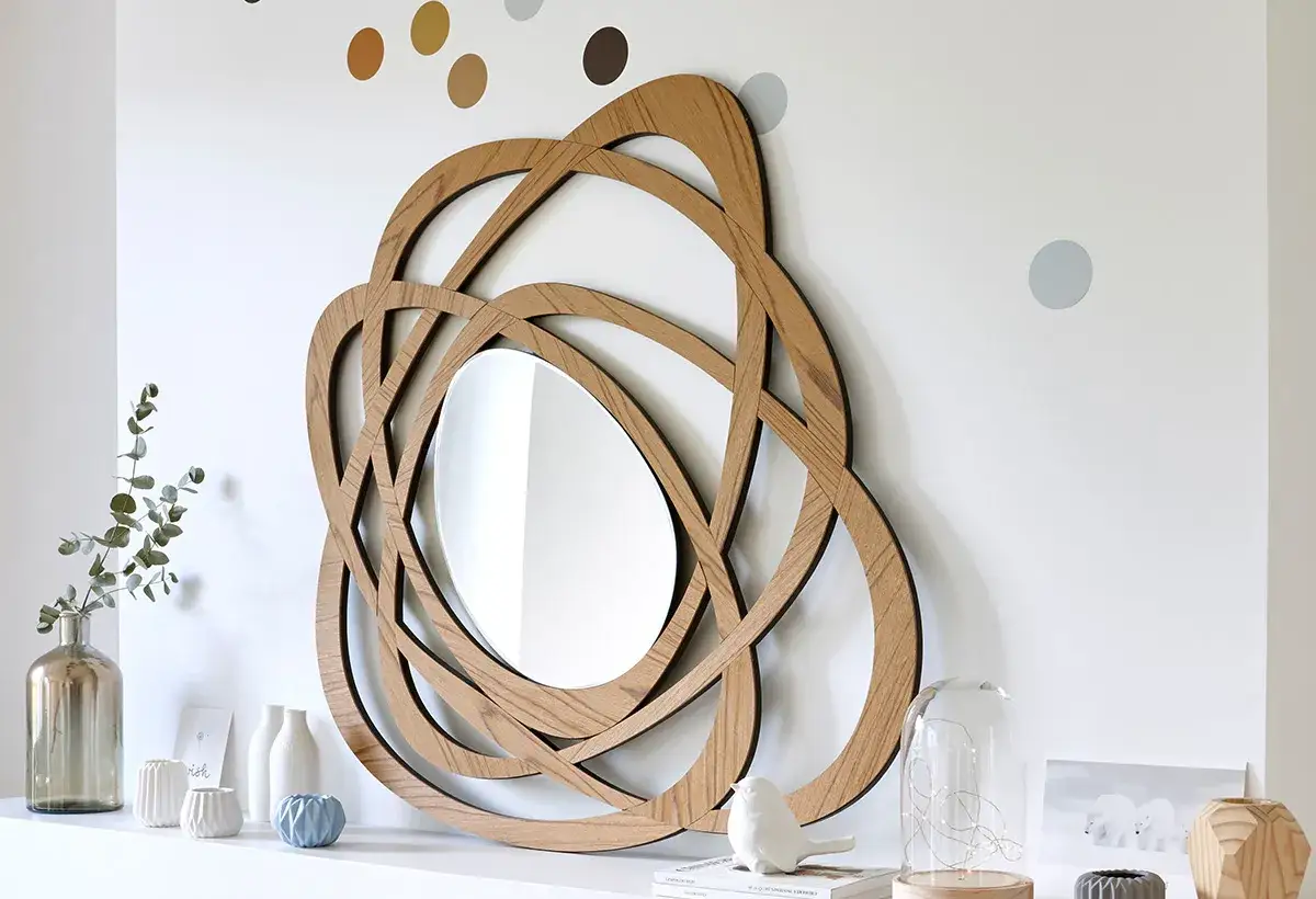 Miroir en bois aux formes entrelacées, une belle idée déco murale à faire soi même. Accompagné de vases et d'une statuette d'oiseau.