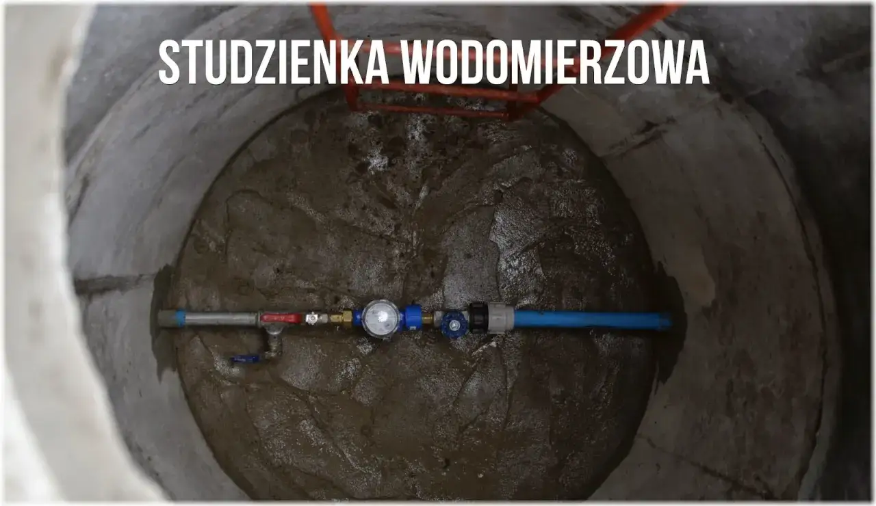 Studzienka wodomierzowa z przyłączem wody do działki bez domu. Widać wodomierz, zawory i rury.