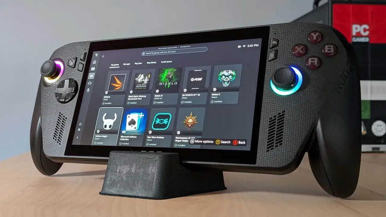 Ręczny komputer do gier, podobny do Xbox, z kolorowymi podświetleniami i ekranem wyświetlającym gry. Ten **Xbox Rogue Ally X** jest gotowy do akcji.