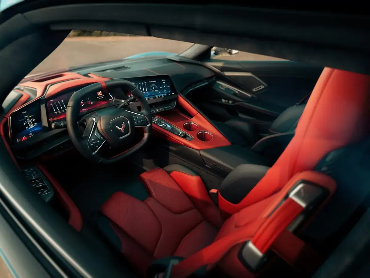 Wnętrze chevrolet corvette c8 z czerwonymi skórzanymi fotelami i nowoczesnym kokpitem.