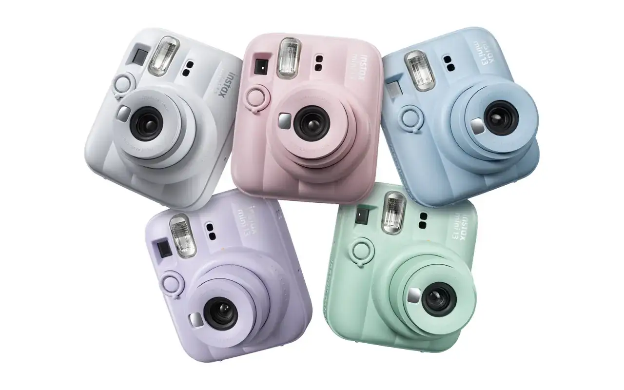 Pięć aparatów Instax Mini 13 w pastelowych kolorach: białym, różowym, niebieskim, fioletowym i miętowym.