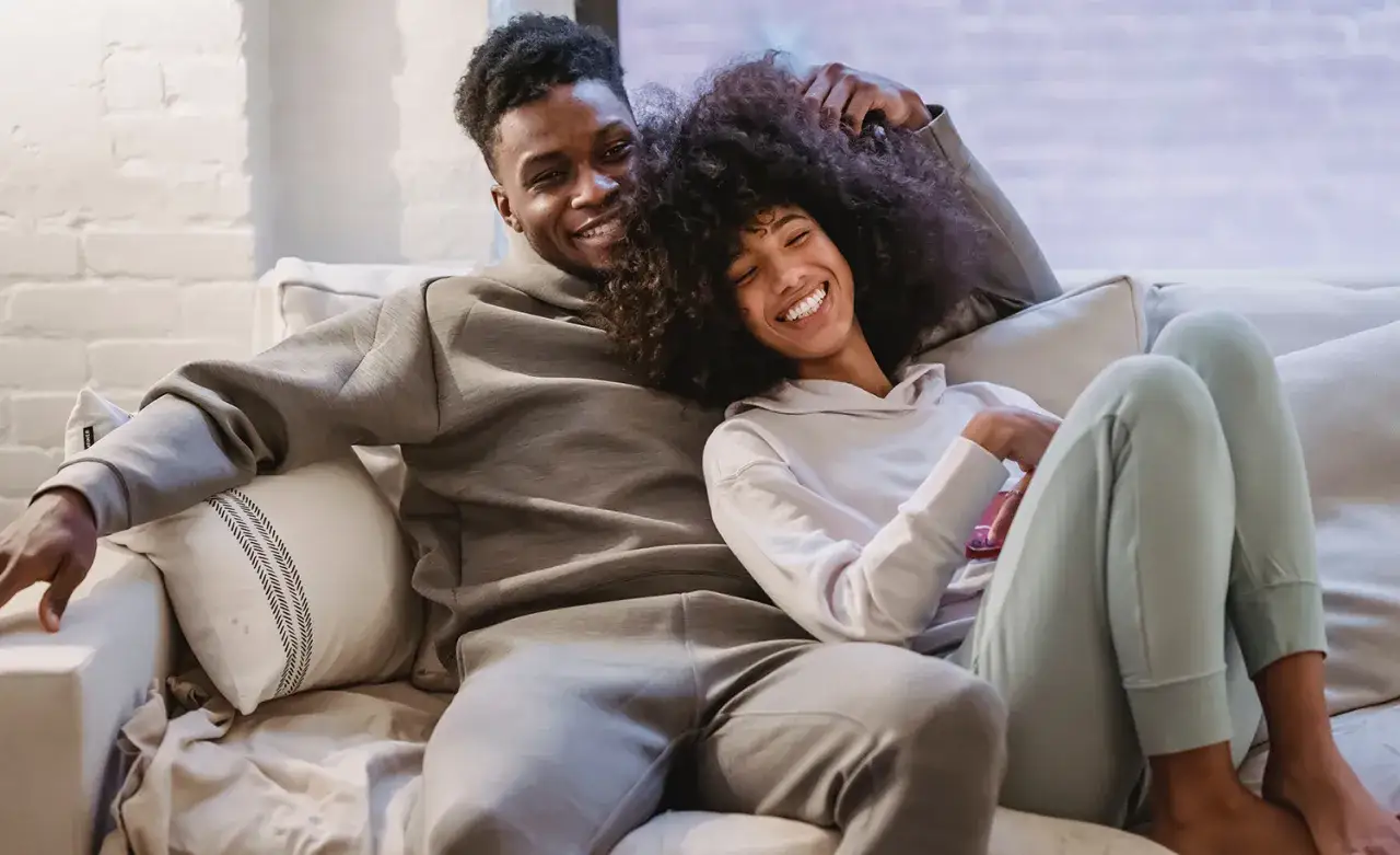 Ett par myser i soffan. Han ler mot kameran, hon lutar sig mot honom. En lugn stund som visar hur det kan vara att leva med en introvert person.