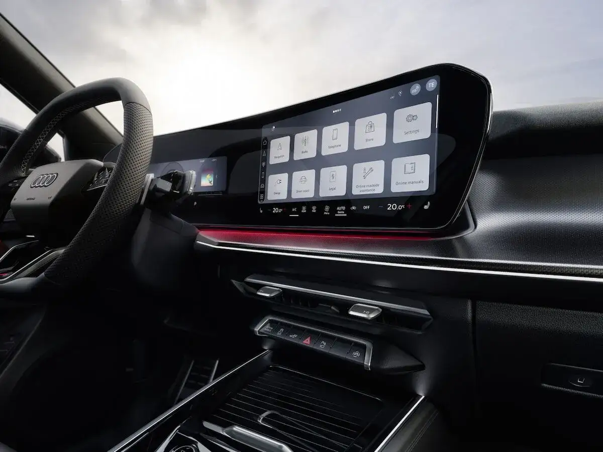 Wnętrze nowego Audi Q3 z dużym ekranem dotykowym systemu infotainment, kierownicą i konsolą środkową.