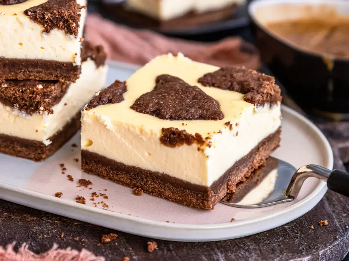Ein Stück russischer Zupfkuchen vom Blech mit cremigem Käse und Schokostückchen.